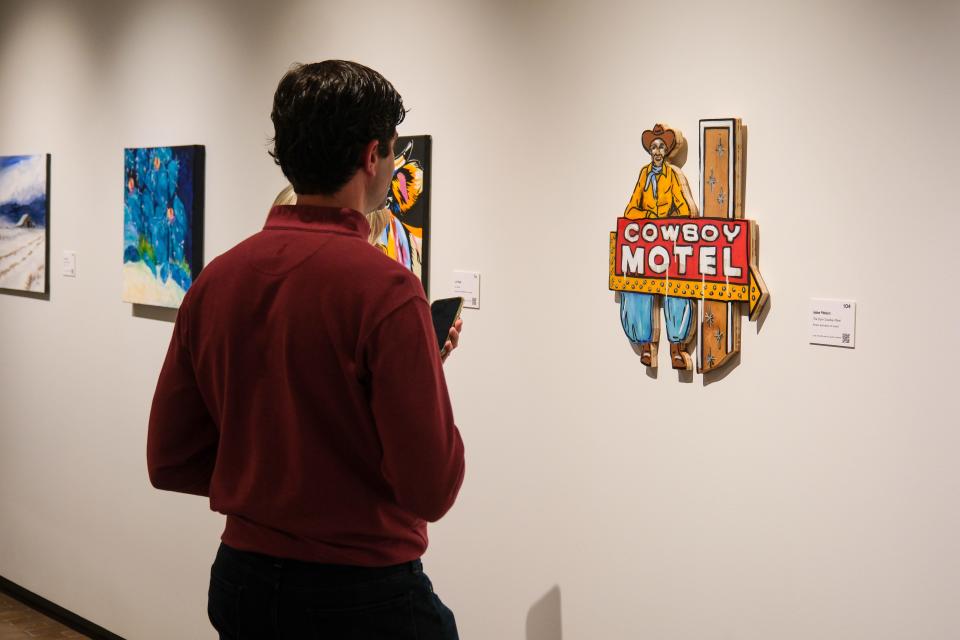 An attendee puts in a bid on a painting at the 20x20 Art Exhibition and Silent Auction at the Amarillo Museum of Art on the campus of Amarillo College.