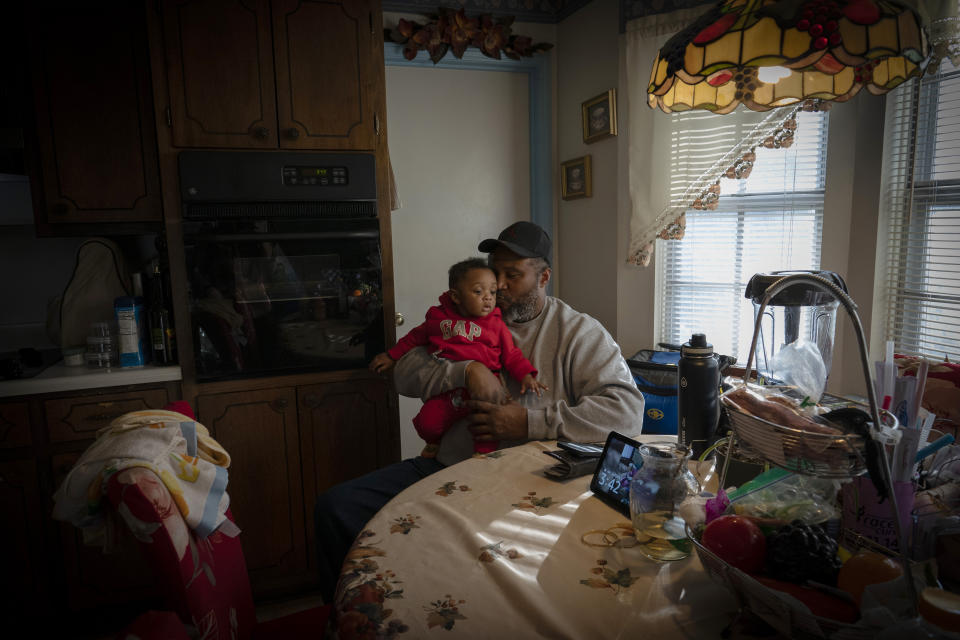 James Lyons kisses his grandson, Adrien Lyons, in the kitchen of his home in Birmingham, Ala., on Saturday, Feb. 5, 2022. (AP Photo/Wong Maye-E)