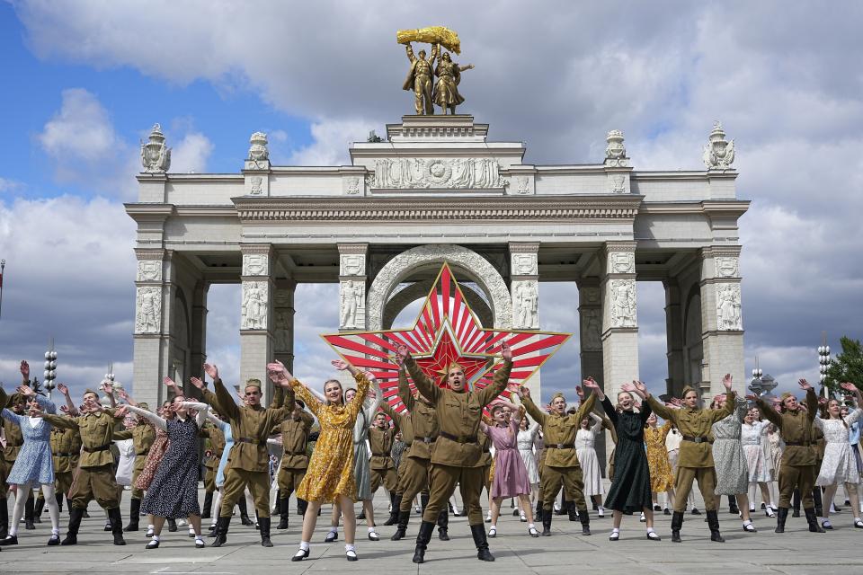 FILE - Moscow students dressed in the fashion of the middle of the last century and Soviet style uniform perform "Victory Waltz" as a part of Victory Day celebration in front of the historical main gates of VDNKh, The Exhibition of Achievements of National Economy, with the red star in the background in Moscow, Russia, Saturday, May 6, 2023. In Russia, history has long become a propaganda tool used to advance the Kremlin's political goals. In an effort to rally people around the flag, the authorities have sought to magnify the country's past victories while glossing over the more sordid chapters of its history. (AP Photo, File)