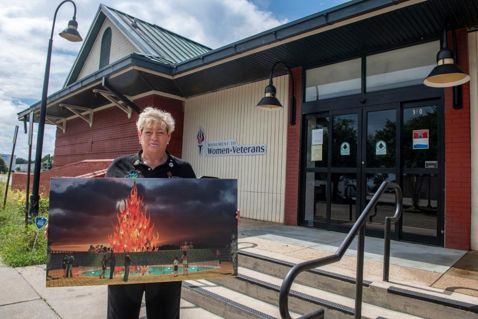 Michelle Caldwell, founder of the Monument to Women Veterans, holds a rendering of the monument. The finished monument will feature a flame rising more than 30 feet into the air and include a stainless-steel elliptical band of flowing water.