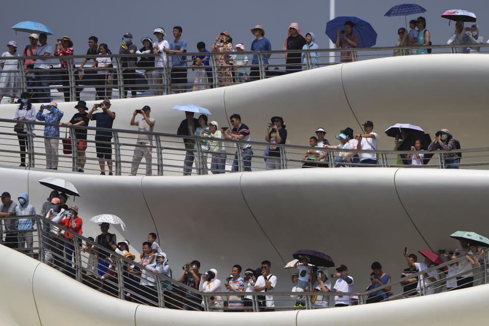 People stand on a bridge to watch the dragon boat races during the Dragon Boat Festival at a canal in Tongzhou, outskirts of Beijing, Monday, June 10, 2024. The Duanwu Festival, also known as the Dragon Boat Festival, falls on the fifth day of the fifth month of the Chinese lunar calendar and is marked by eating rice dumplings and racing dragon boats. (AP Photo/Andy Wong)