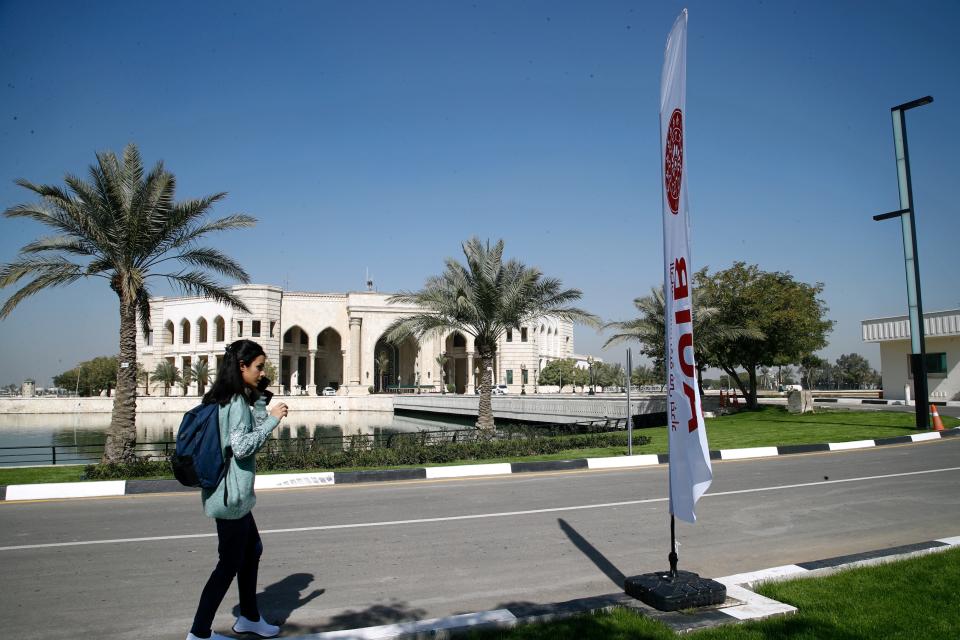 A student walks outside the newly inaugurated American University in Baghdad, Iraq, Monday, Feb. 15, 2021. Encircled by the blue waters of a man-made lake are palaces turned to faculties promising an "American" schooling to meet the needs of Iraq's growing youth, in a city where education has lagged since the 2003 U.S.-led invasion that toppled Saddam Hussein and unemployment has since soared. (AP Photo/Hadi Mizban)