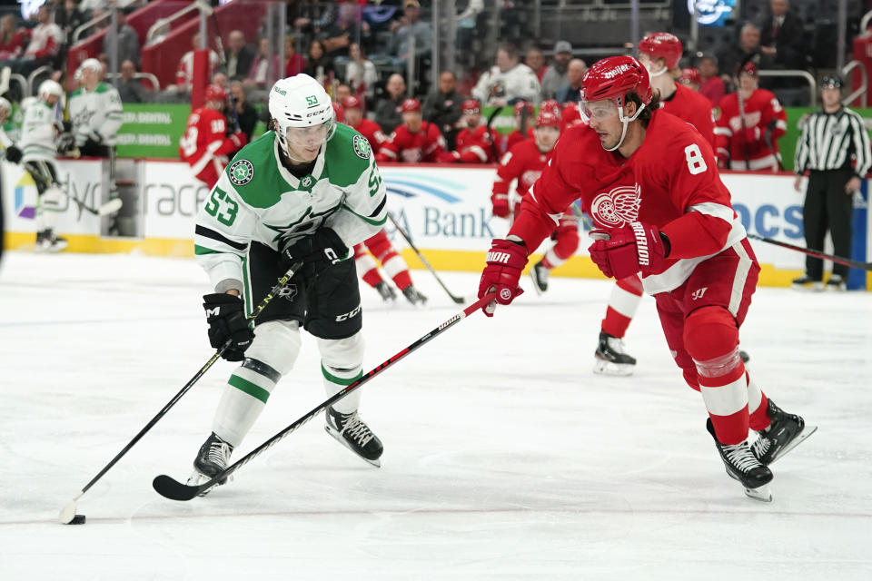 Dallas Stars center Wyatt Johnston (53) attacks with the puck as Detroit Red Wings' Ben Chiarot (8) defends in the first period of an NHL hockey game Monday, April 10, 2023, in Detroit. (AP Photo/Paul Sancya)