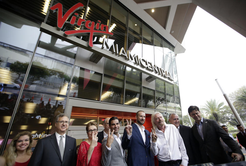 Richard Branson, of Virgin Group, third from right, poses with officials at a naming ceremony for the Brightline train station, to be renamed as Virgin MiamiCentral, Thursday, April 4, 2019, in Miami. The state's Brightline passenger trains are being renamed Virgin Trains USA after Branson invested in the new fast-rail project that is scheduled to connect Miami with Orlando. (AP Photo/Lynne Sladky)