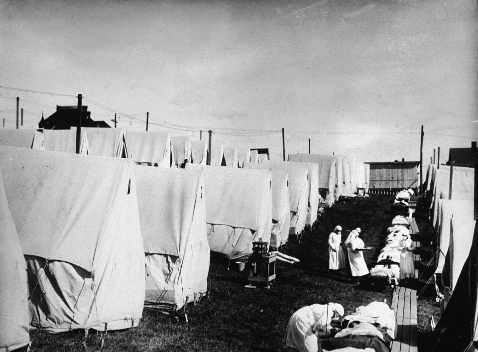 Nurses care for victims of a Spanish influenza epidemic outdoors amidst canvas tents during an outdoor fresh air cure, Lawrence, Massachusetts, 1918 (Photo by Hulton Archive/Getty Images)