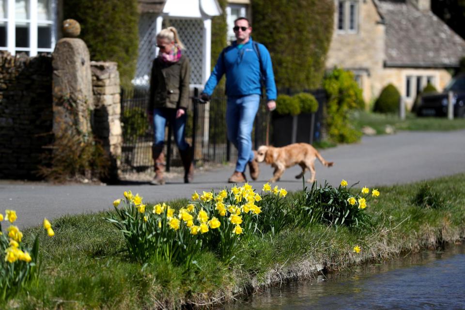 Dog walkers in the village of Lower Slaughter in the Cotswolds, Gloucestershire (PA)