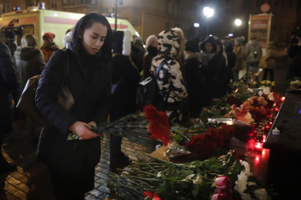 A woman lays flowers at the well-known military choir's building in Moscow. Photo: AP