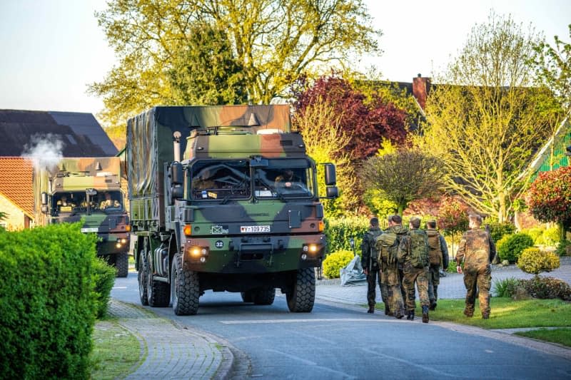 Armed forces officers walk through the missing boy's home. Six-year-old Arian from Elm is still missing as the search for him continues. Sina Schuldt/dpa