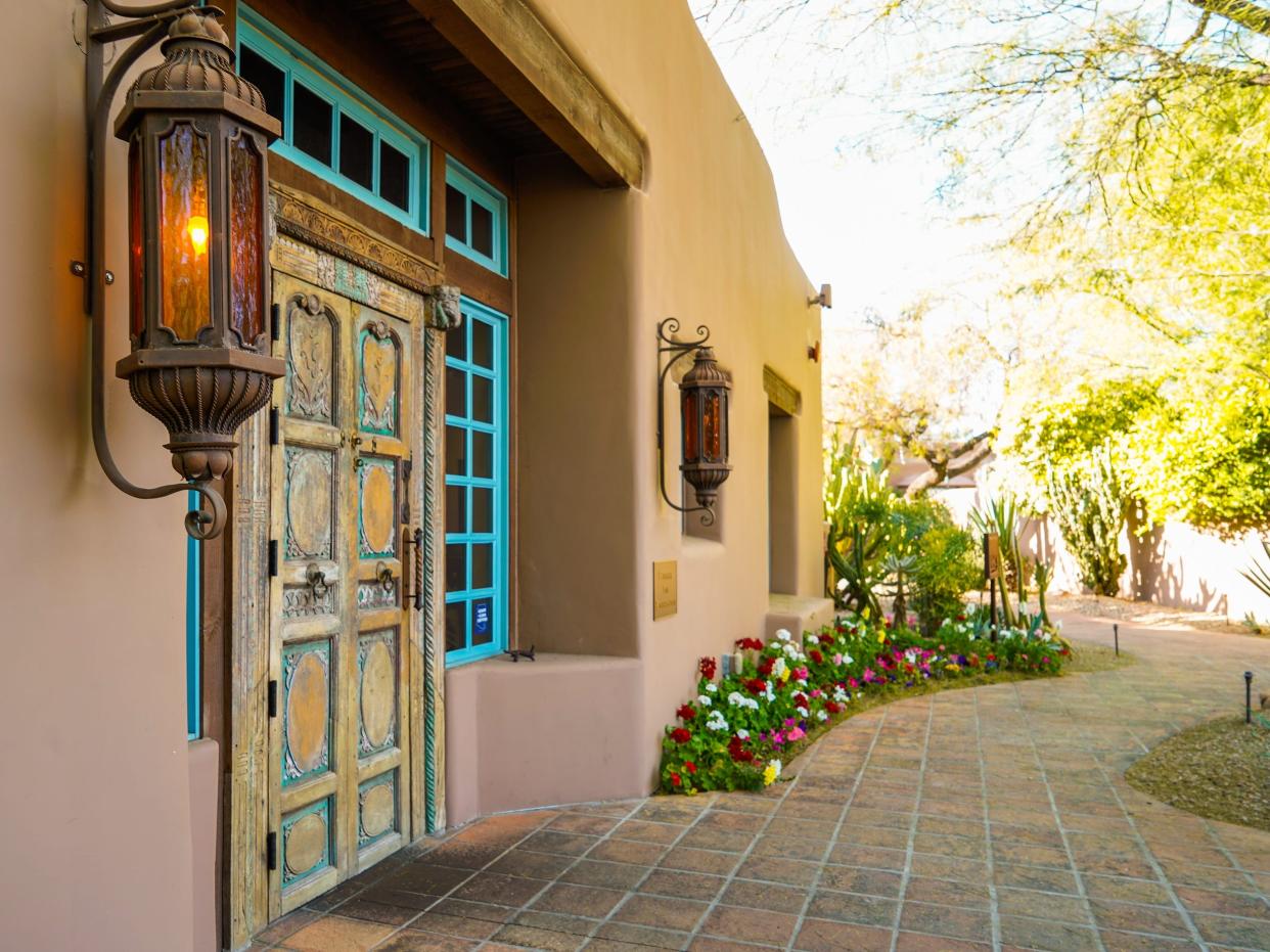 An adobe building on the left and a garden path on the right at Hermosa Inn