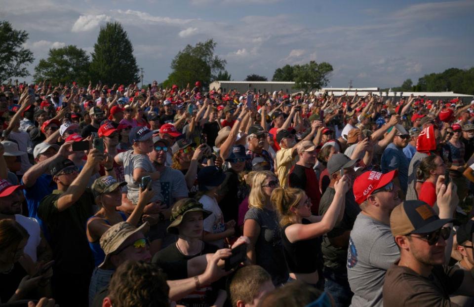 Donald Trump supporters raise their phones to film during a campaign rally in front of the buildings from which the shooter, Matthew Thomas Crooks, fired at the former president in an assassination attempt during a campaign rally.