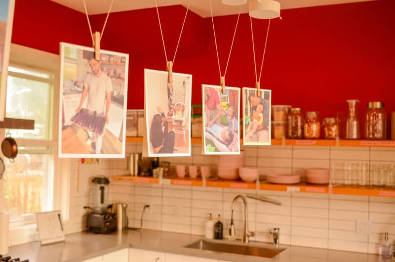 Pictures of dwellers hanging in kitchen of communal home.