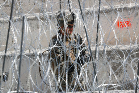 A U.S. Marine helps to make a concertina wire barricade at the U.S. Mexico border in preparation for the arrival of a caravan of migrants at the San Ysidro border crossing in San Diego, California, U.S., November 13, 2018. REUTERS/Mike Blake