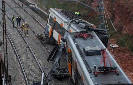 Rescue workers survey the scene after a commuter train derailed between Terrassa and Manresa, outside Barcelona, Spain, November 20, 2018. REUTERS/Albert Gea