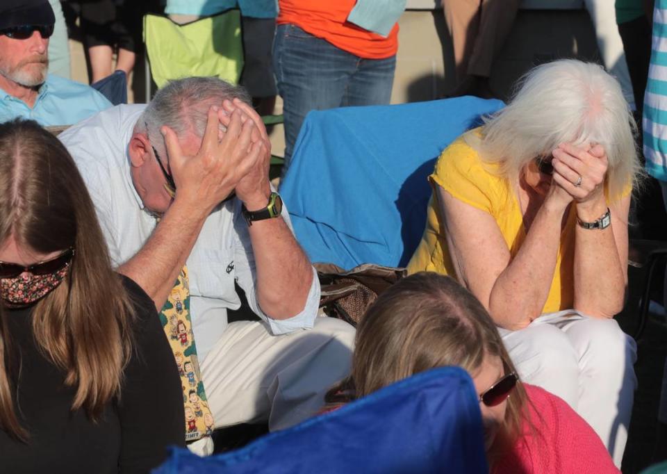 Mourners pray Sunday at a vigil to remember Robert and Barbara Lesslie, their grandchildren Adah and Noah, all of Rock Hill; Robert Shook and James Lewis of Gastonia.