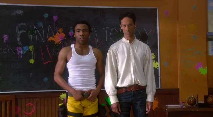 Troy and Abed standing in the anthropology room, which is splattered with paint, in "Community"