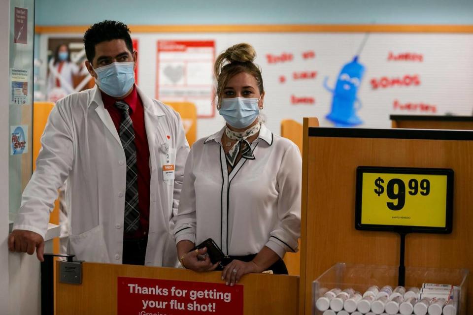 Navarro Discount Pharmacy employees attend a press conference where Florida Gov. Ron DeSantis spoke at their store in Hialeah on Tuesday, Feb. 23, 2021. DeSantis announced that dozens of CVS Pharmacy y más and Navarro Discount Pharmacy stores will join the immunization effort.