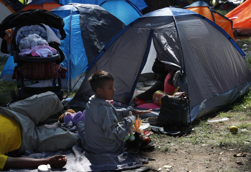 A migrant child sits outside a tent, taking shelter at the Jesus Martinez stadium in Mexico City, Tuesday, Nov. 6, 2018. Humanitarian aid converged around the stadium in Mexico City where thousands of Central American migrants winding their way toward the United States were resting Tuesday after an arduous trek that has taken them through three countries in three weeks. (AP Photo/Marco Ugarte)