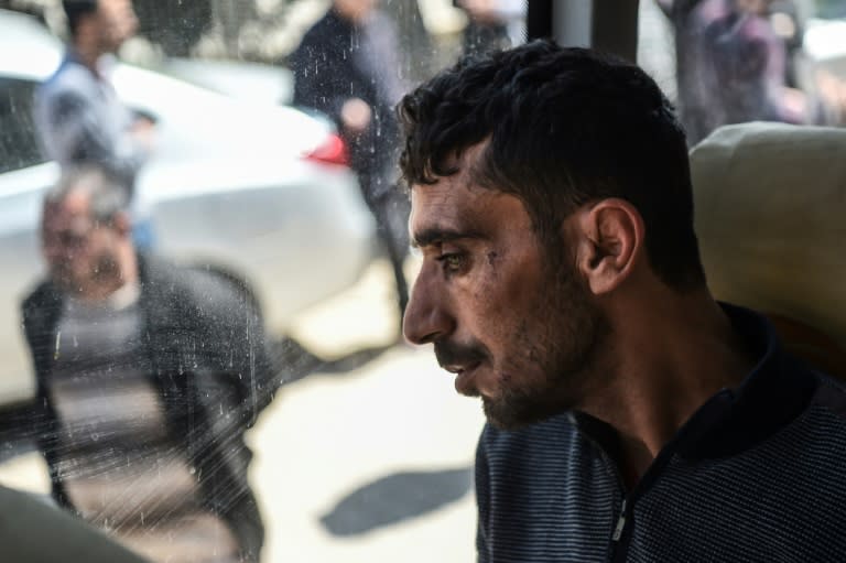 A man looks on in a bus carrying Syrian victims of suspected chemical attack back to the Syrian border after treatment at Reyhanli hospital in Hatay on April 7, 2017