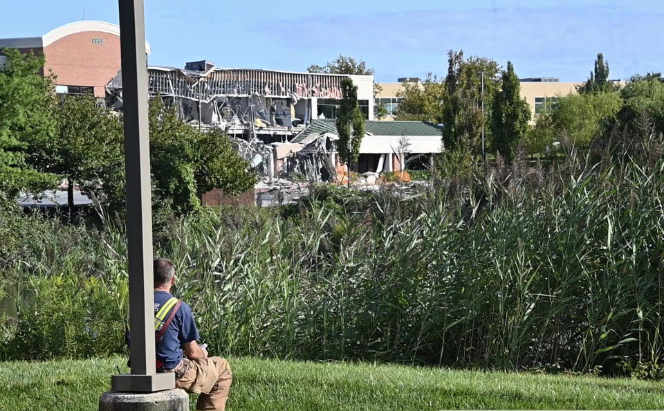 A Howard County emergency responder looks on at the damage caused by a gas explosion at the Lakeside Office Park in Columbia, Md., Sunday, Aug. 25, 2019. The shopping center was evacuated. The explosion caused a power outage in the area. (Kevin Richardson/The Baltimore Sun via AP)