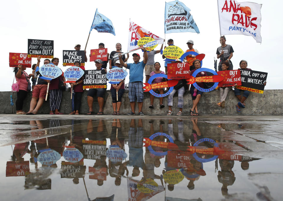 FILE - Protesters display placards and shout slogans in a continuing protest against China over its coast guards' alleged seizure of fish caught by Filipino fishermen near the contested Scarborough Shoal in the South China Sea on June 14, 2018 by the baywalk in Manila, Philippines. Philippine officials on Monday, Sept. 25, 2023 condemned a floating barrier laid by Chinese coast guard vessels to prevent Filipino fishermen from entering a disputed lagoon in the South China Sea and said they would take actions to remove the obstruction. (AP Photo/Bullit Marquez, File)