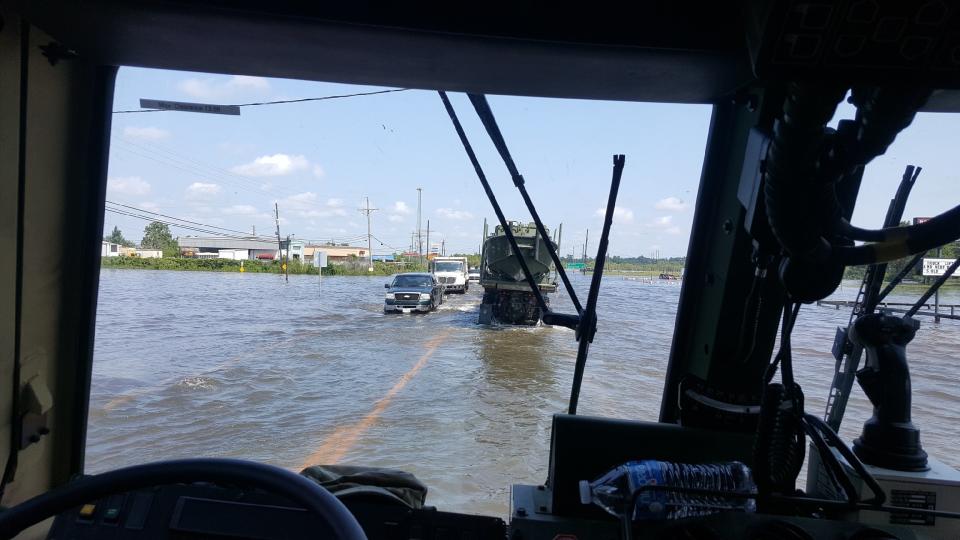 Light medium tactical vehicle's (LMTV) make their way through floodwaters near Bridge City in Texas.