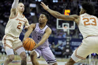 Kansas State guard Tylor Perry (2) looks to pass between Texas guard Chendall Weaver (2) and forward Dillon Mitchell (23) during the first half of an NCAA college basketball game Wednesday, March 13, 2024, in Kansas City, Mo. (AP Photo/Charlie Riedel)