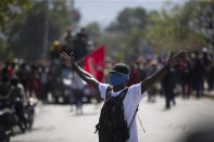 A factory worker takes part in a protest demanding a salary increase, in Port-au-Prince, Haiti, Thursday, Feb. 10, 2022. The workers employed at factories that produce textiles and other goods say they make 500 gourdes ($5) a day for nine hours of work and are seeking a minimum of 1,500 gourdes ($15) a day. (AP Photo/Odelyn Joseph)