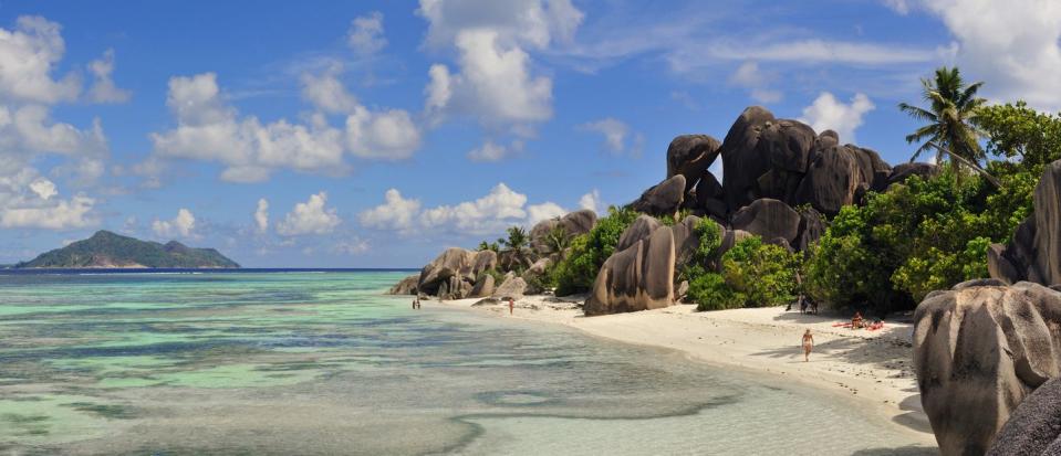 a beach with rocks and trees with railay beach in the background