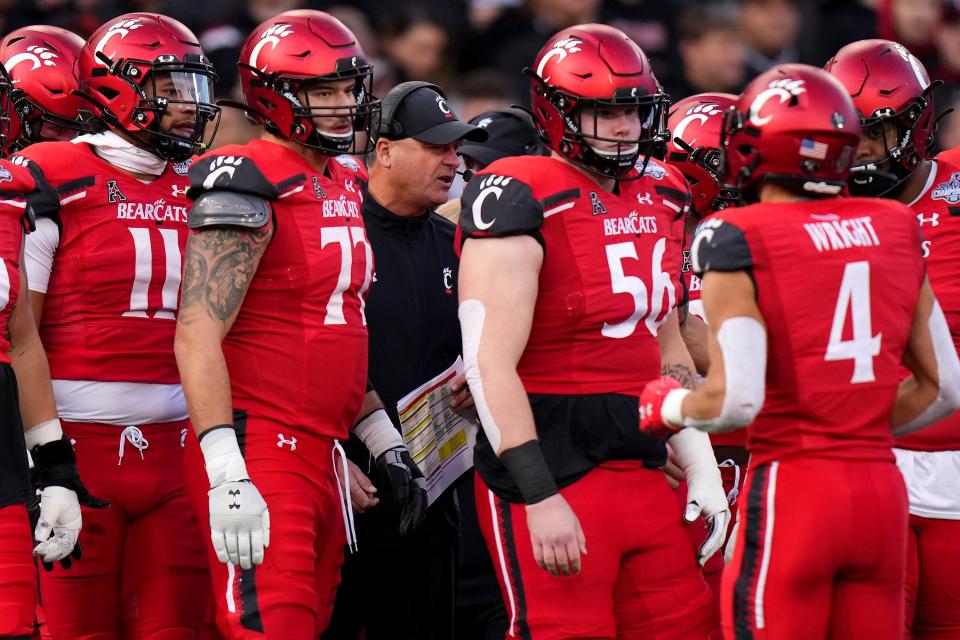 Cincinnati Bearcats offensive coordinator Mike Denbrock, center, talks with the offense before they take the field in the first quarter during the American Athletic Conference championship football game against the Houston Cougars, Saturday, Dec. 4, 2021, at Nippert Stadium in Cincinnati. 