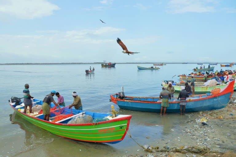 Fishermen return to shore at Kollam beach: they have been hailed as heroes for their work rescuing flood victims