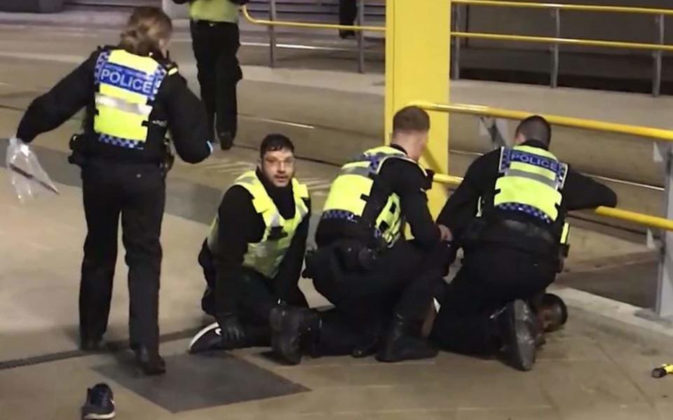 Police restraining a man after he stabbed three people at Victoria Station in Manchester on New Year's Eve - PA