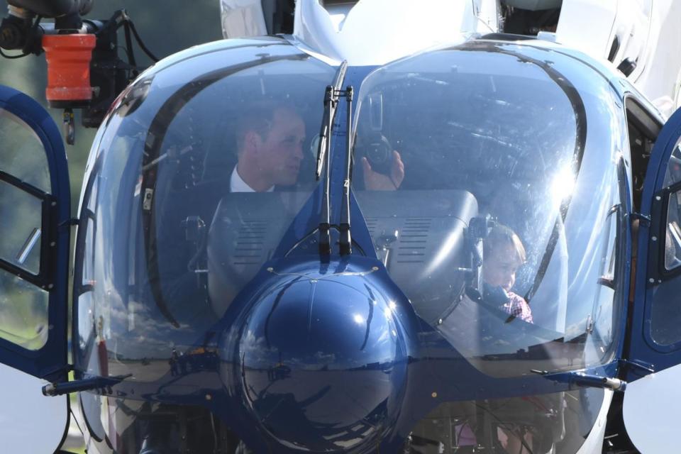 Prince William pictured in the cockpit of an Airbus helicopter with son George (AFP)