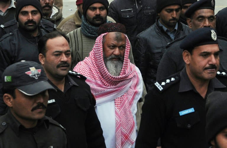 Pakistani police escort the head of banned extremist group Lashkar-e-Jhangvi (LeJ) Malik Ishaq (C) as he arrives at the high court in Lahore on December 22, 2014