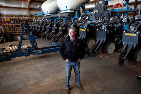 Soybean farmer Austin Rincker poses for a photograph near his planter equipment at his farm in Moweaqua, Illinois, U.S., March 6, 2019. REUTERS/Daniel Acker/Files