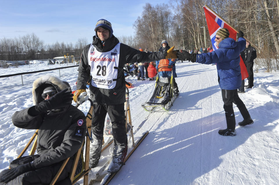 Defending champion Joar Leifseth Ulsom is greeted by local fan Ole Andersson during the ceremonial start of the Iditarod Trail Sled Dog Race Saturday, March 2, 2019 in Anchorage, Alaska. (AP Photo/Michael Dinneen)