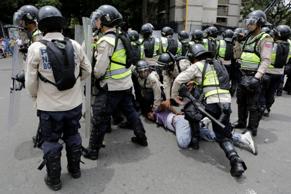 Un opositor es reprimido por policías durante una manifestación contra el gobierno de Nicolás Maduro en Caracas el 18 de mayo de 2016. (REUTERS/Carlos Garcia Rawlins)