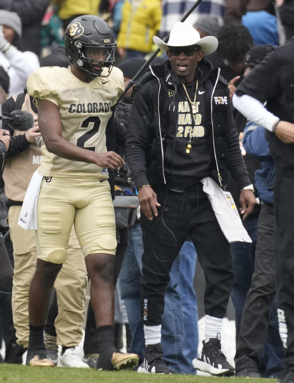 Colorado quarterback Shedeur Sanders, left, walks with his father, head coach Deion Sanders, before the team's spring NCAA college football game, Saturday, April 22, 2023, in Boulder, Colo. (AP Photo/David Zalubowski)