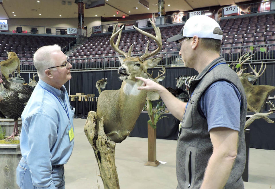 Ray Kowalski, left, and Jens Jorgensen of the Pennsylvania Taxidermist Assocciation, look at a pedestal mount of  a deer Friday at the Kovalchick Convention and Athletic Complex in Indiana, Pa. 