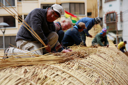 Builders work on top of the 'Viracocha III', a boat made only from the totora reed, as it is being prepared to cross the Pacific from Chile to Australia on an expected six-month journey, in La Paz, Bolivia, October 19, 2016. REUTERS/David Mercado