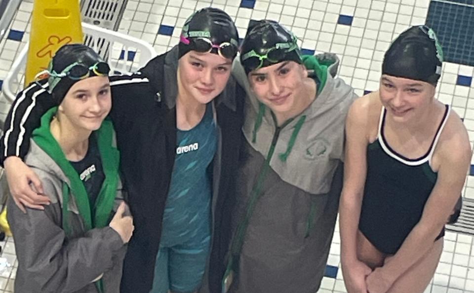 Hammerhead swimmers (from left) Hadley Corlew, Parker Ford, Maeve Riley, Claire Wedge get their photo taken at the USA Michigan Age Group States (MAGS) Championship meet in Holland.