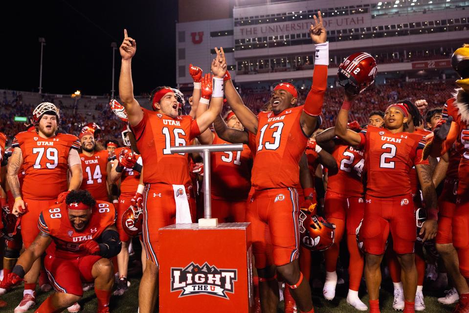 Utah quarterbacks Bryson Barnes (16) and Nate Johnson (13) celebrate their win and combined effort against the Florida Gators at Rice-Eccles Stadium on Thursday night.
