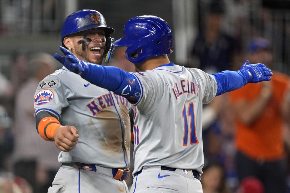 New York Mets' Francisco Alvarez, left, celebrates with teammate Jose Iglesias, right, after Iglesias hit a two-run home run during the 10th inning of a baseball game against the Washington Nationals at Nationals Park, Monday, July 1, 2024, in Washington. (AP Photo/Mark Schiefelbein)