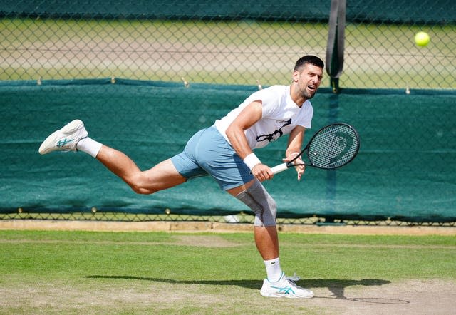 Novak Djokovic hits a running backhand as he trains at Wimbledon (