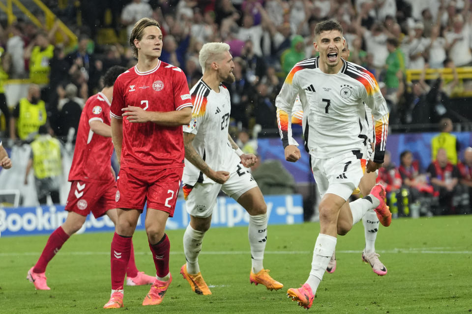 Germany's Kai Havertz celebrates after scoring his side's opening goal from a penalty kick next to Denmark's Joachim Andersen during a round of sixteen match between Germany and Denmark at the Euro 2024 soccer tournament in Dortmund, Germany, Saturday, June 29, 2024. (AP Photo/Andreea Alexandru)