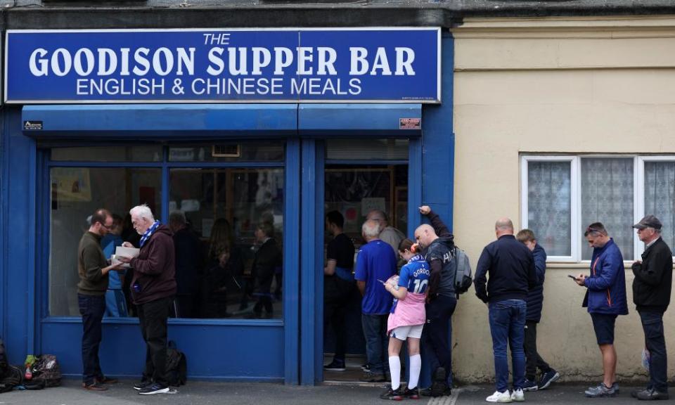 Fans wait outside a a takeaway shop before the Everton v West Ham match.