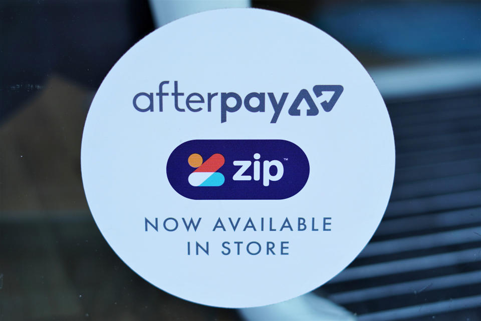 A logo for the companies Afterpay and Zip is seen in a shop window.