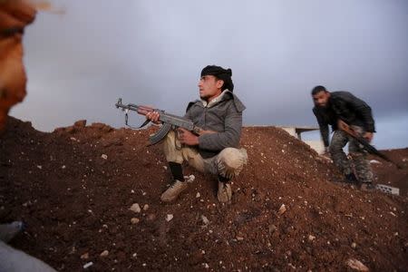 Rebel fighters of the Al-Furqan brigade sit on a look-out point with their weapons in Aziziyah village, southern Aleppo countryside, Syria March 5, 2016. REUTERS/Khalil Ashawi