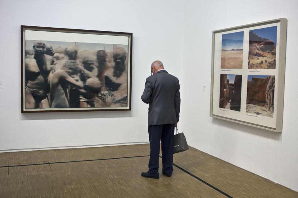 A member of media looks at paintings of German artist Gerhard Richter on the eve of the opening of his exhibition "Gerhard Richter: Panorama", at the Centre Pompidou, Monday, June 4, 2012. On left: "Neger", 1964, and at right, "Egyptian Landscape", 1964. (AP Photo/Thibault Camus)