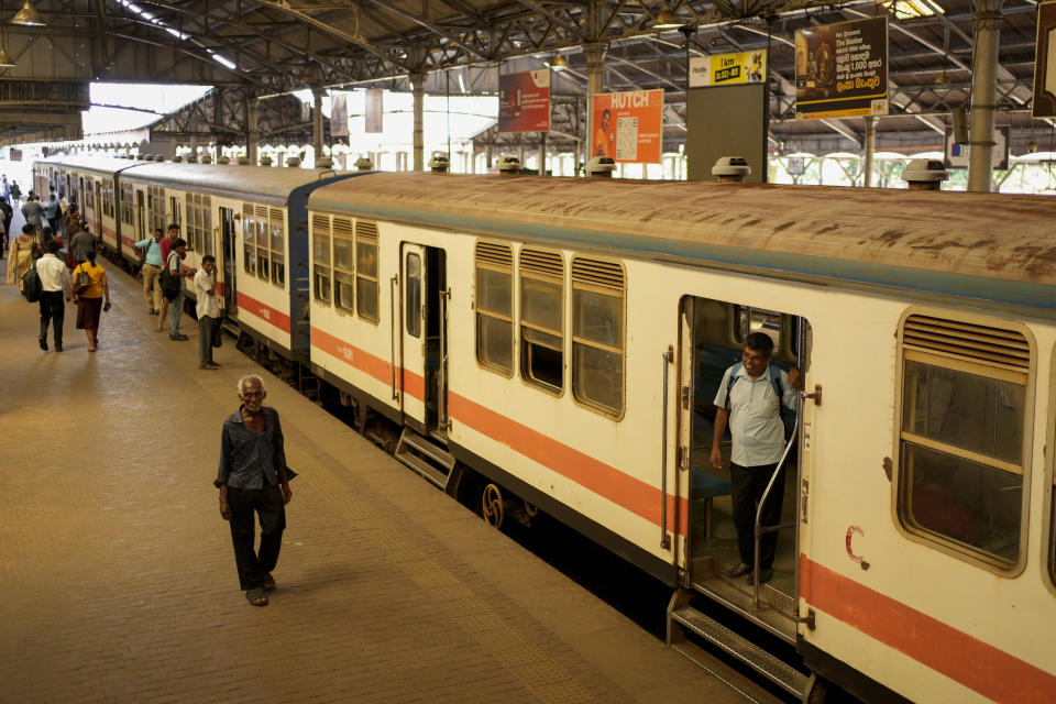 Passengers walk on a platform next to a train during a railway union strike in Colombo, Sri Lanka, Wednesday, July 10, 2024. (AP Photo/Eranga Jayawardena)