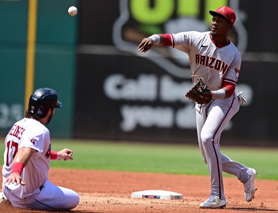 Arizona Diamondbacks shortstop Geraldo Perdomo, right, forces out Cleveland Guardians' Austin Hedges at second base as he relays to first during the second inning of a baseball game, Wednesday Aug. 3, 2022, in Cleveland. Guardians' Steven Kwan was out at first for a double play. (AP Photo/David Dermer)